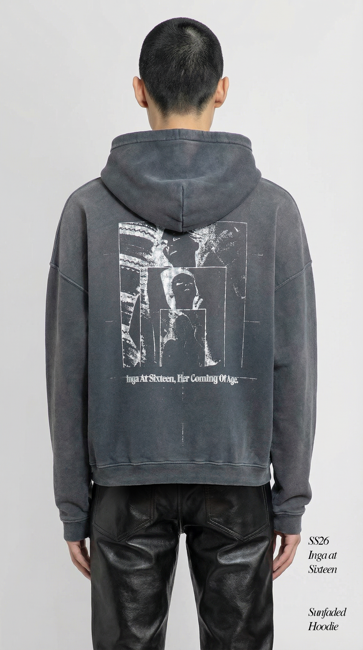 Person wearing a gray hoodie with a graphic design on the back against a white background